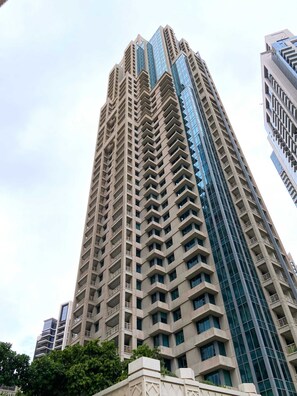 A high-rise building with a modern architectural design, featuring multiple balconies and a mix of glass and concrete facades. - Silkhaus Elite 1bdr at 29 Boulevard Downtown (Dubai)