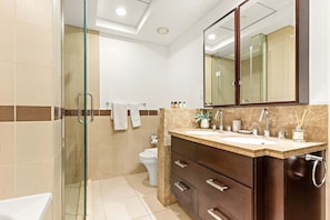 A modern bathroom with a glass shower enclosure, a toilet, and a vanity with a large mirror. - Silkhaus Elite 1bdr at 29 Boulevard Downtown (Dubai)