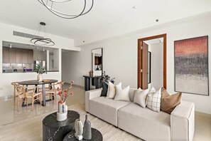 Ein modernes Wohnzimmer mit Sofa, Couchtisch und Essbereich.