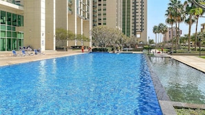Uma piscina com espreguiçadeiras e um pequeno elemento aquático no centro.