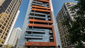 Un edificio de varios pisos con un diseño moderno, que cuenta con un restaurante en la planta baja.