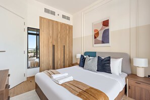 A modern bedroom with a large bed, wooden wardrobe, and a city view. - Silkhaus Elite 1bdr Stay in Al Maryah Vista Tower (Abu Dhabi)