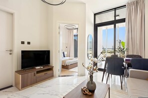 A modern hotel room with a TV, a dining area, a bed, and a view of the city. - Silkhaus Elite 1bdr Stay in Al Maryah Vista Tower (Abu Dhabi)