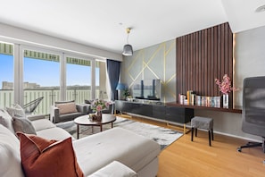 A modern living room with a sofa, coffee table, and TV stand. - Silkhaus Premium 2bdr Near Al Rahah Al Sana (Abu Dhabi)