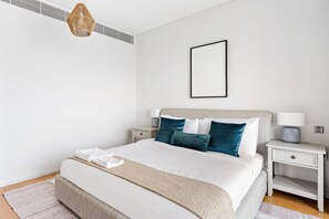 A neatly arranged bedroom with a bed, bedside tables, a hanging light fixture, and a framed picture on the wall. - Silkhaus Premium 2bdr Near Al Rahah Al Sana (Abu Dhabi)