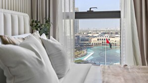 Habitació d'hotel moderna amb una finestra gran que ofereix vistes a la ciutat i a la riba del riu.