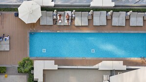 Zona de piscina al terrat amb gandules i ombrel·les.