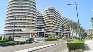 Un edificio moderno de varios pisos con fachada curva y balcones.
