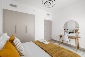 Quarto moderno com cama, escrivaninha e guarda-roupa.