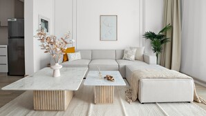 En moderne stue med sofa, to sofaborde og en dekorativ plante.