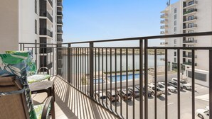 Ein Balkon mit Blick auf einen Parkplatz und ein Schwimmbecken.