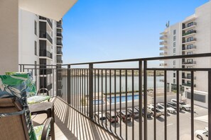Ein Balkon mit Blick auf einen Parkplatz und ein Schwimmbecken.