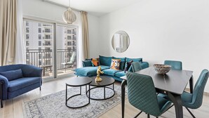 Ein modernes Wohnzimmer mit einer Couch, zwei Sesseln, einem Couchtisch und einem Esstisch.