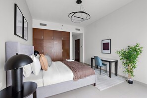 A modern bedroom with a bed, bedside table, chair, wardrobe, and a potted plant. - Silkhaus Luxurious 1bdr in Reem Island ARC Tower (Abu Dhabi)