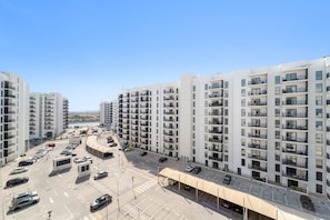 Un complexe d’appartements moderne composé de plusieurs immeubles de grande hauteur, doté d’un parking et offrant une vue dégagée sur les environs.