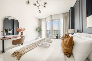 A modern hotel room with a large bed, a desk, a chair, a mirror, and a view of the city. - Silkhaus 1bdr Executive Stay in Radiant Heights (Abu Dhabi)