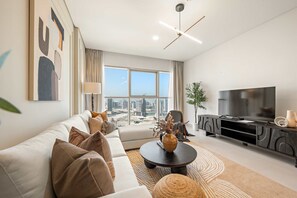A modern living room with a sofa, coffee table, and TV stand. - Silkhaus 1bdr Executive Stay in Radiant Heights (Abu Dhabi)