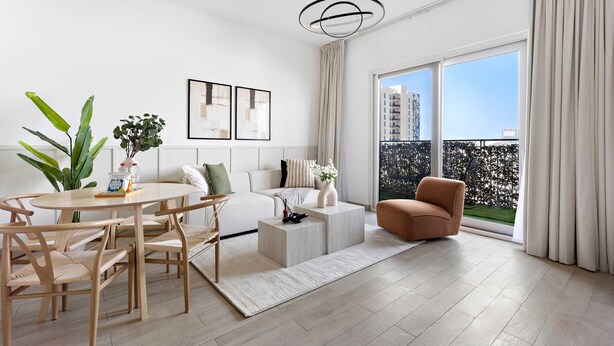 A modern living room with a round dining table, wooden chairs, a sofa, a coffee table, and a large window with curtains. - Silkhaus Unique Deal Modern 2bdr Canal View (Abu Dhabi)
