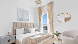 A bedroom with a bed, bedside table, lamp, and a view of the outdoors. - Silkhaus Lavish 3BR Maid Yas Island (Abu Dhabi)