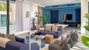 Una sala de estar moderna con un sofá, una mesa de centro y una zona de televisión.