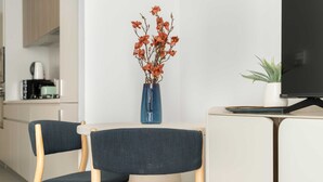 Una cocina moderna con cafetera, un florero y un televisor sobre un mueble.