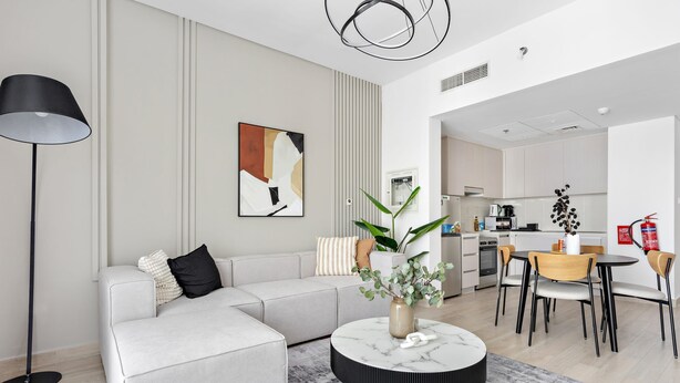 Ein modernes Wohnzimmer mit einer Couch, einem Couchtisch und einem Essbereich mit Stühlen und einem Tisch.