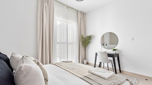 Ein modernes Schlafzimmer mit Bett, Schreibtisch und Spiegel.