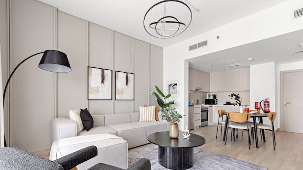 Una sala de estar moderna con sofá, mesa de centro y comedor.