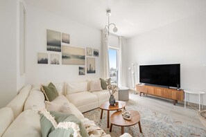 A modern living room with a sofa, coffee table, and TV. - Silkhaus Canal View 3bdr Maid Near Ferrari World (Abu Dhabi)