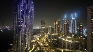 A nighttime cityscape with high-rise buildings, a river, and a well-lit highway. - Silkhaus Luxury 2bdr Dubai Creek Harbour (Dubai)