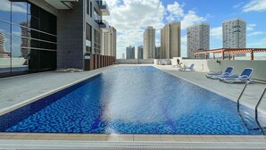 Una piscina en la azotea con vistas despejadas a edificios altos aledaños.