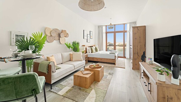 A modern living room with a sofa, coffee table, and TV. There is a dining area with chairs and a table. The room has large windows and a view of the outside. - Silkhaus Studio on Palm New Modern Sea View (Dubai)