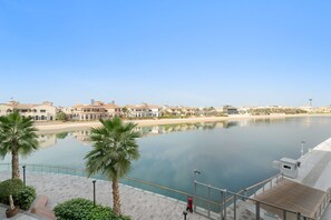 A waterfront hotel with a pool, palm trees, and a beach view. - Silkhaus Studio on Palm New Modern Sea View (Dubai)