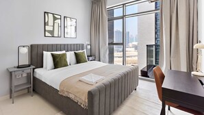 A modern hotel room with a large bed, a desk, and a view of the city. - Silkhaus Spacious 1BR Najmat Reem Island (Abu Dhabi)