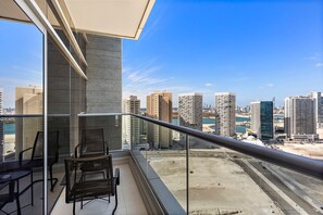 A balcony with a view of a cityscape, including tall buildings and a body of water. - Silkhaus Urban 1bdr Near Reem Central Park (Abu Dhabi)