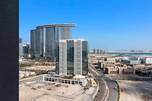 A high-rise building with a distinctive curved top, surrounded by other modern skyscrapers and a clear blue sky. - Silkhaus Urban 1bdr Near Reem Central Park (Abu Dhabi)