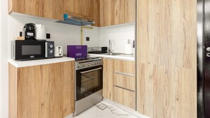 Une cuisine moderne dotée de meubles en bois, d’un four à micro-ondes, d’une machine à café, d’un grille-pain et d’une cuisinière.