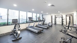 Ett gym med löpband, en motionscykel och styrketräningsmaskiner.