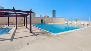 Ein Dachpool mit Liegestühlen und einer Pergola.