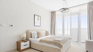 A modern bedroom with a large bed, bedside table, and a chair. - Silkhaus Julphar Tower By Al Fay Park Al Reem (Abu Dhabi)
