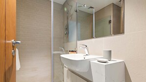 A modern bathroom with a glass shower enclosure, a white sink, and a large mirror. - Silkhaus 1bdr Near Reem Park at Julphar Tower (Abu Dhabi)