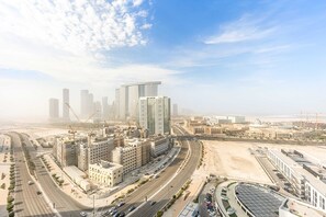 A modern urban area with high-rise buildings, roads, and construction cranes. - Silkhaus Cityscape 1BR Najmat (Abu Dhabi)
