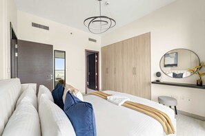 A modern bedroom with a large bed, a wardrobe, a mirror, and a ceiling light fixture. - Silkhaus Signature 1bdr Najmat Al Reem Island (Abu Dhabi)