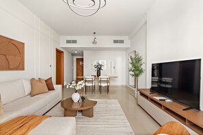 En moderne stue med sofa, sofabord, tv og spiseplads.