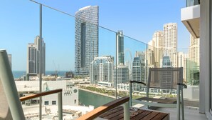 A balcony with a view of a cityscape, including high-rise buildings and a body of water. - Silkhaus Luxury 1BR Marina Star Dubai Marina (Dubai)