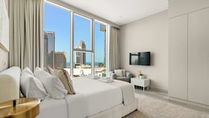 A modern hotel room with a large bed, a TV, and a view of the cityscape. - Silkhaus Luxury 1BR Marina Star Dubai Marina (Dubai)