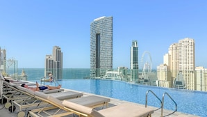 A rooftop pool with lounge chairs and a city skyline in the background. - Silkhaus Luxury 1BR Marina Star Dubai Marina (Dubai)