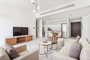 Ein modernes Wohnzimmer mit Flachbildfernseher, Sofa und Couchtisch.