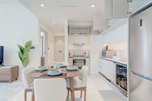 A modern kitchen with white cabinetry, a built-in oven, and a dishwasher. - Silkhaus Elegant 1bdr Sea View Private Beach (Dubai)