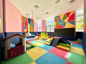 A playroom with colorful walls, a playhouse, and various play equipment. - Silkhaus Large Studio Madison Res High Floor (Dubai)